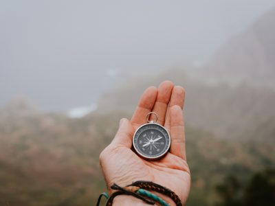 Looking at the compass to figure out right direction. Foggy valley and mountains in background. Santo Antao. Cape Cabo Verde