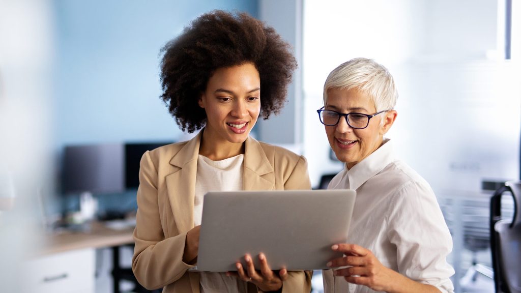 Two women discussing with laptop