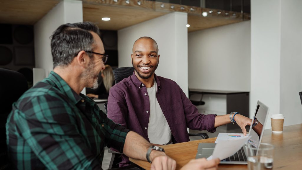 Two colleagues smiling and looking at each-other